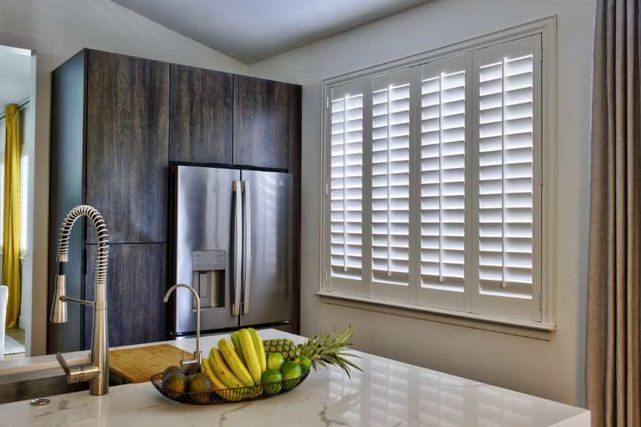 Large window with interior shutters in a kitchen.