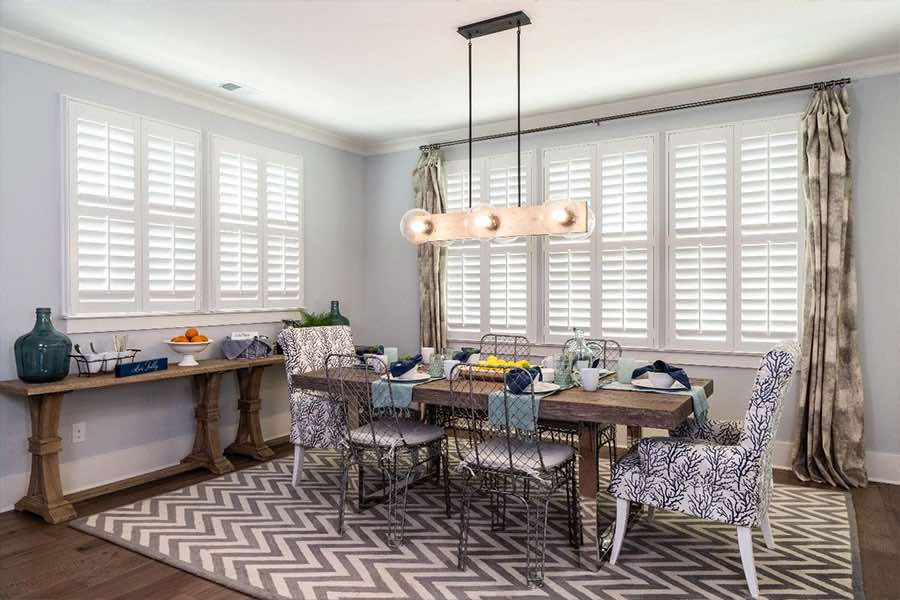 Polywood shutters and curtains on dining room windows of different sizes