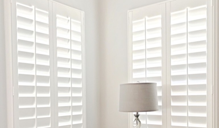 Plantation shutters come in a variety of neutral whites and wood stains. Plantation shutters in a corner window.