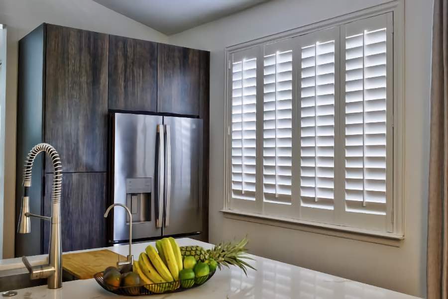 Homeowners use indoor window shutters in Honolulu when they want attractive and functional window treatments. Polywood shutters on a large kitchen window