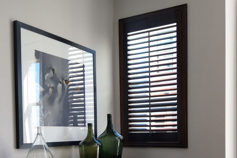 Black painted wood shutters in a corner window area.