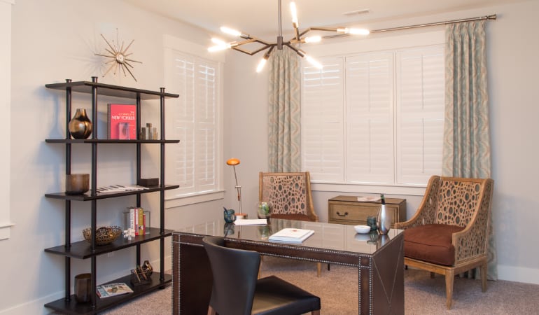 Picking the right window treatments can result in an increase in natural light. Honolulu home office with plantation shutters.